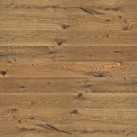 Rustikales Eiche-Parkett mit lebendiger Maserung, natürlichen Ästen und schwarz gespachtelten Rissen in warmem Holzfarbton.