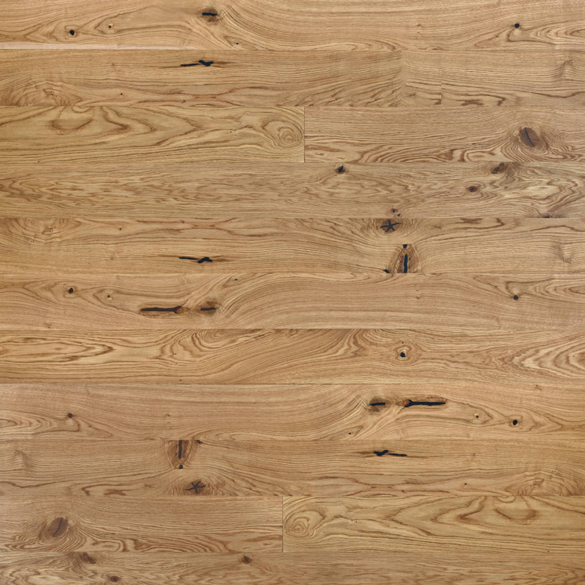 Rustikales Eiche-Parkett mit lebendiger Maserung, natürlichen Ästen und schwarz gespachtelten Rissen in warmem Holzfarbton.