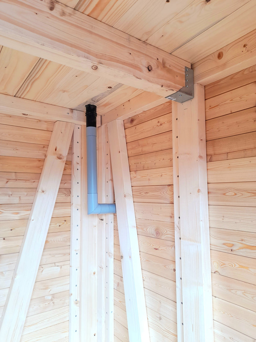 Innenansicht eines Holz-Gartenhauses mit sichtbarer Rahmenkonstruktion und innenliegendem Fallrohr aus PVC