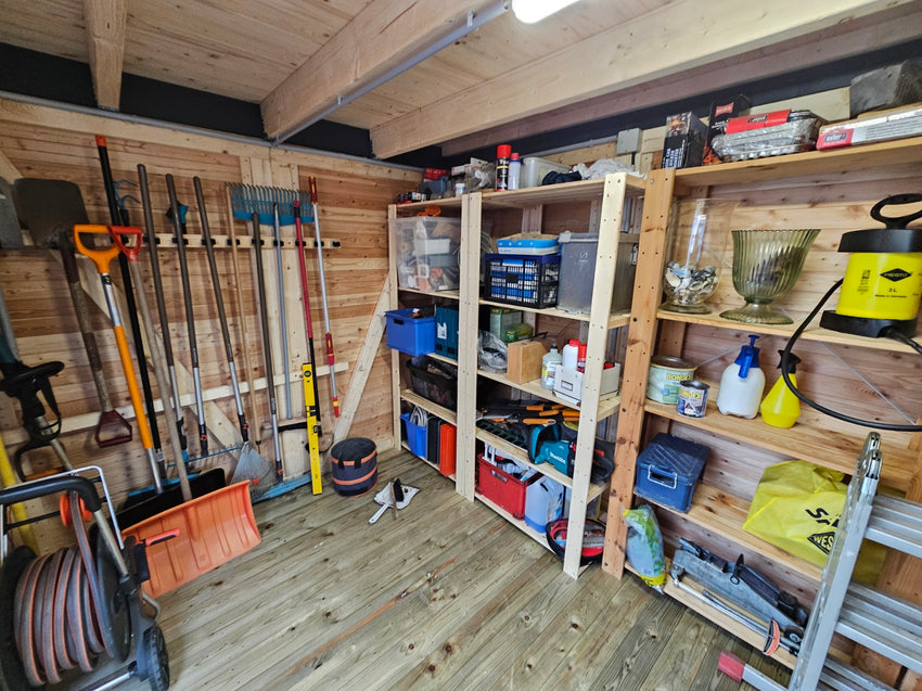 Innenansicht eines gut organisierten Holz-Gartenhauses mit Regalen, Werkzeugen, Gartengeräten und Aufbewahrungsboxen