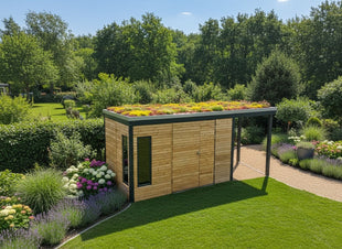 Modernes Gartenhaus aus Lärchenholz mit Gründach und seitlichem Vordach, umgeben von gepflegtem Rasen und Blumenbeeten.
