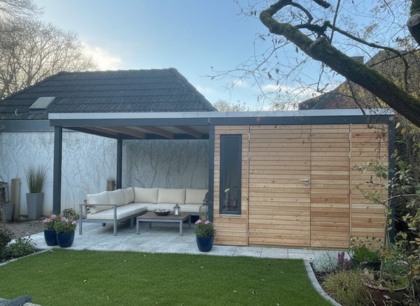 Modernes Gartenhaus aus Lärche mit Rhombusschalung, Doppeltür und seitlichem überdachten Loungebereich, eingebettet in einen gepflegten Garten.