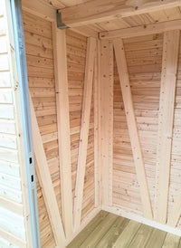 Innenansicht eines hochwertigen Gartenschranks aus Massivholz mit Rhombussfassadenprofil, stabiler Holzrahmenkonstruktion und imprägniertem Holzboden.