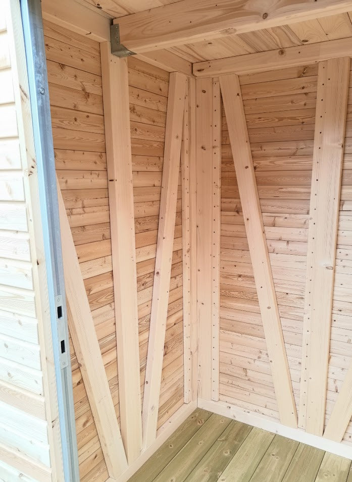 Innenansicht eines hochwertigen Gartenschranks aus Massivholz mit Rhombussfassadenprofil, stabiler Holzrahmenkonstruktion und imprägniertem Holzboden.