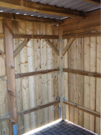 Innenansicht vom Holzgerätehaus Classic mit sichtbarer Rahmenkonstruktion, Profilwänden und Pflasterboden