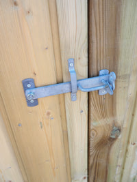 Dänischer Torverschluss an einer Holzgerätetür, Detailaufnahme der verzinkten Beschläge auf senkrechten Profilbrettern.