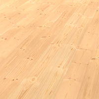 Unbehandelter Kiefernholzboden mit heller, natürlicher Maserung und sichtbaren Aststellen in weich wirkender, gleichmäßiger Dielenstruktur.