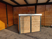 Massive Mülltonnenbox KLARE LINIE aus Lärchenholz im modernen Rhombusdesign, zweiflügelig, vor Sichtschutzzaun und Carport platziert.