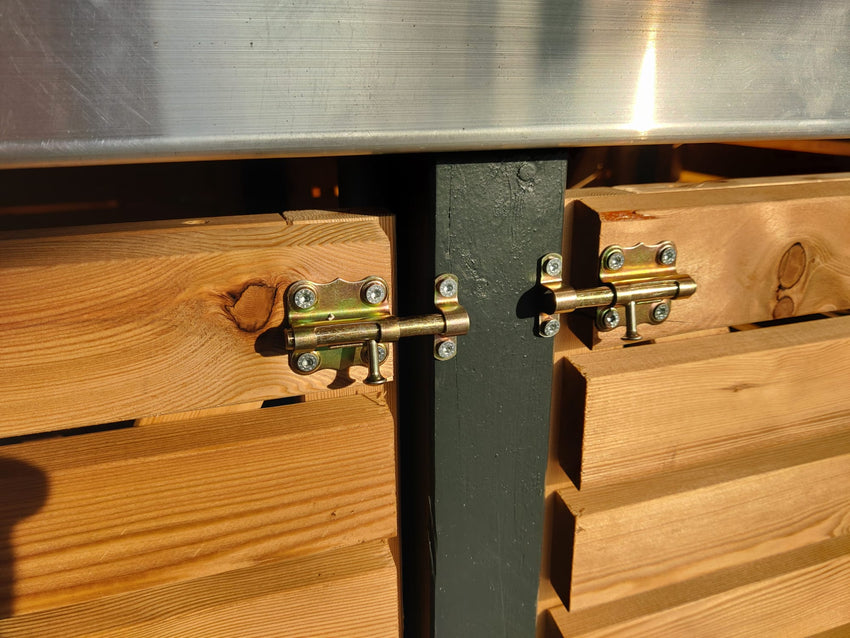 Detailansicht der Verriegelung an der Mülltonnenbox KLARE LINIE aus Lärchenholz, mit zwei Metallriegeln an der Tür.
